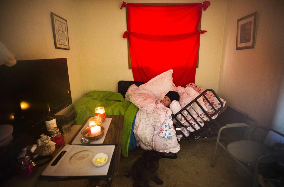 Helen Wilson lies under a pile of blankets, in a house which has had no power or heating for over five days, after an ice storm in Toronto