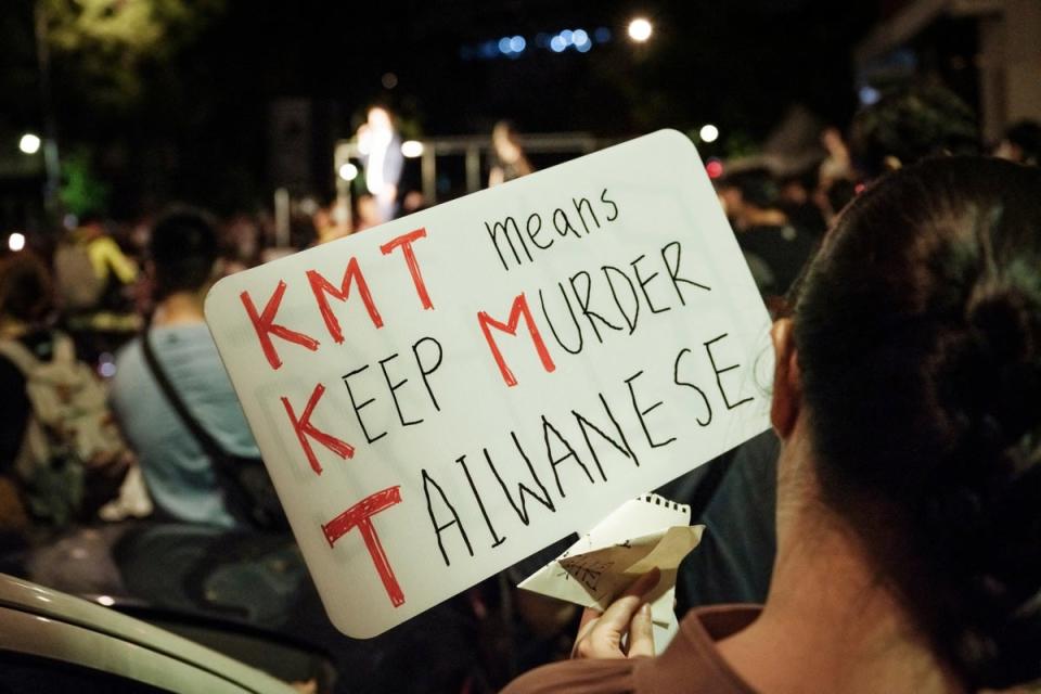 A protester holds a placard outside the Legislative Yuan in Taipei (AFP via Getty)