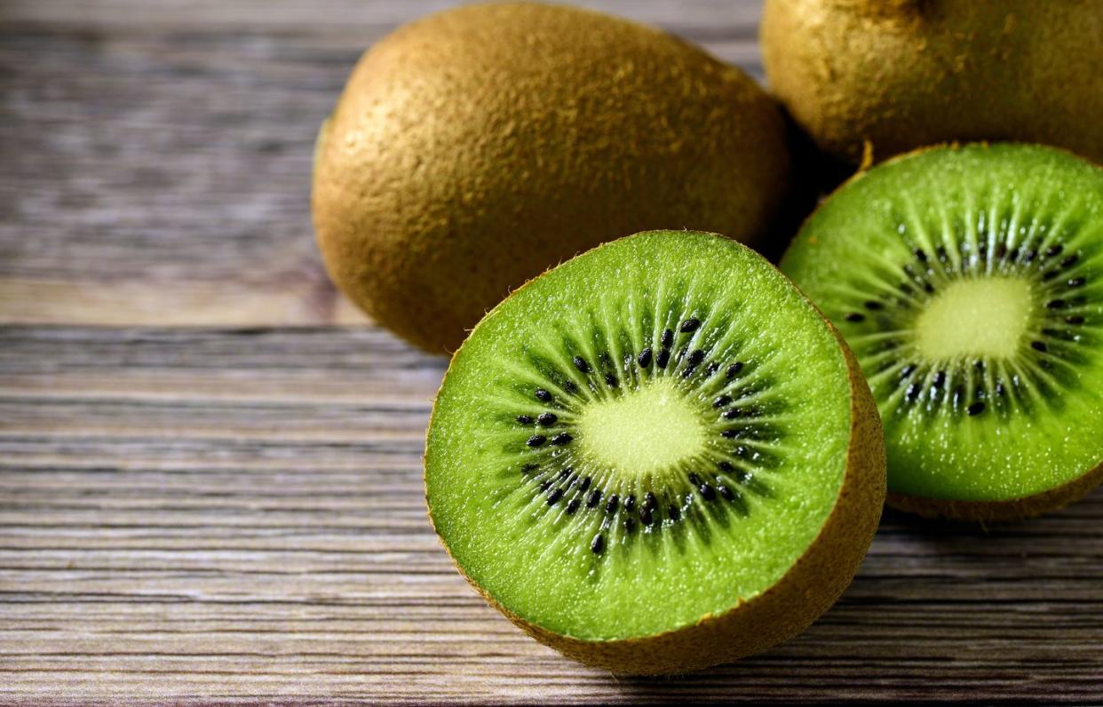 sliced fresh kiwi fruit on wood table