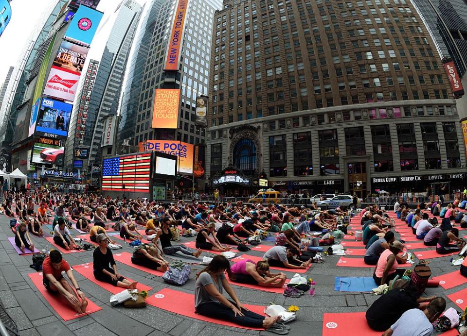 People practice yoga in New York's Times Square as they celebrate the summer solstice on June 21, 2015. (Photo credit DON EMMERT/AFP/Getty Images) 