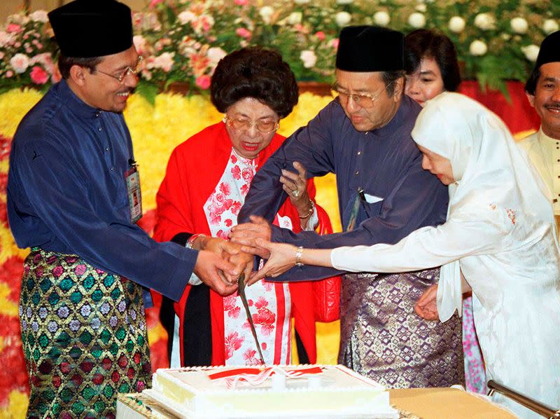 FILE PHOTO: Malaysian Prime Minister Mahathir Mohamad cuts a cake with help from his wife Siti Hasmah, his deputy Anwar Ibrahim and Anwar's wife Wan Azizah during UMNO's general assembly in Kuala Lumpur