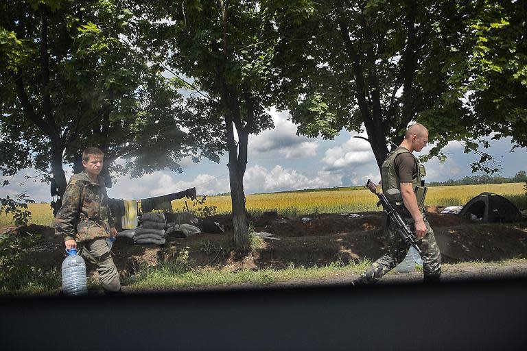 Ukrainian soldiers carry supplies of water at a check point near the eastern city of Slavyansk, on June 11, 2014