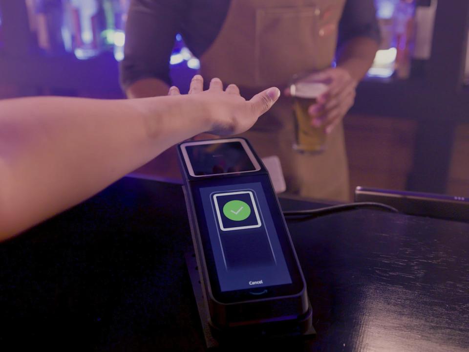 hand hovering over Amazon One palm-scanner