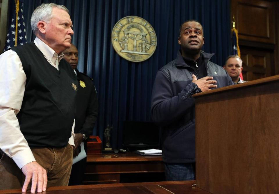 Atlanta Mayor Kasim Reed responds to a pointed question about the city's response to the snow storm as Gov. Nathan Deal looks on, during a news conference Wednesday, Jan. 29, 2014 in the Governor's office at the State Capitol in Atlanta. A rare snowstorm left thousands across the U.S. South frozen in their tracks, with workers sleeping in their offices, students camping in their schools, and commuters abandoning cars along the highway to seek shelter in churches or even grocery stores. (AP Photo/Atlanta Journal-Constitution, Ben Gray) MARIETTA DAILY OUT; GWINNETT DAILY POST OUT; LOCAL TV OUT; WXIA-TV OUT; WGCL-TV OUT