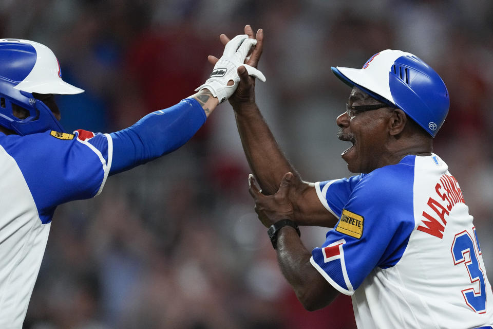 Atlanta Braves' Eddie Rosario, left, is greeted by third base coach Ron Washington (37) as he runs the bases after hitting a two-run home run during the eighth inning of the team's baseball game against the San Francisco Giants on Saturday, Aug. 19, 2023, in Atlanta. (AP Photo/John Bazemore)