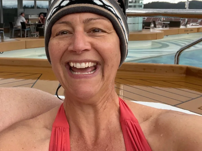 rebecca wearing a swimsuit and a winter hat int he hot tub on the alaskan cruise ship