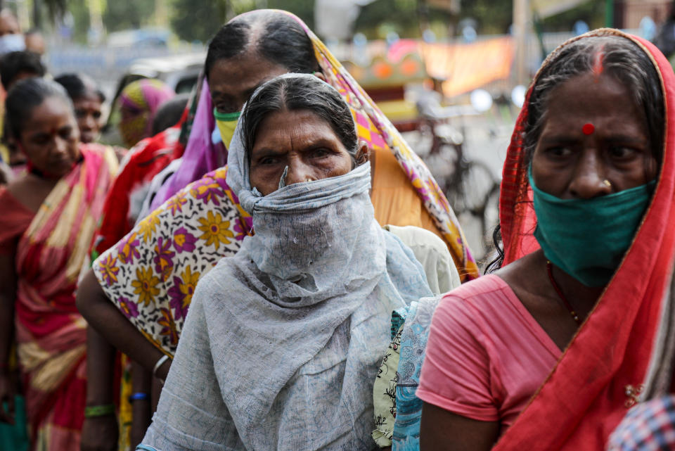 Impoverished people wait outside the Missionaries of Charity, the order founded by Saint Teresa, to receive food distributed on the anniversary of the saint's death in Kolkata, India, Saturday, Sept. 5, 2020. The Nobel Peace Prize winning Catholic nun who spent 45-years serving for the poor, sick, orphaned, and dying, died in Kolkata on this day in 1997 at age 87. (AP Photo/Bikas Das)