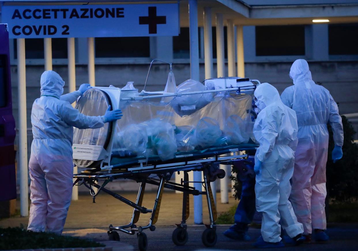 A patient in a biocontainment unit is carried on a stretcher at the Columbus Covid 2 Hospital in Rome, on Monday, March 16, 2020. The new Columbus Covid 2 Hospital, an area fully dedicated to the COVID-19 cases at the Gemelli university polyclinic, opened today with 21 new ICU units and 32 new beds, in order to support the regional health authorities in trying to contain the pandemic. Sign at top in Italian reads "Admission COVID 19".