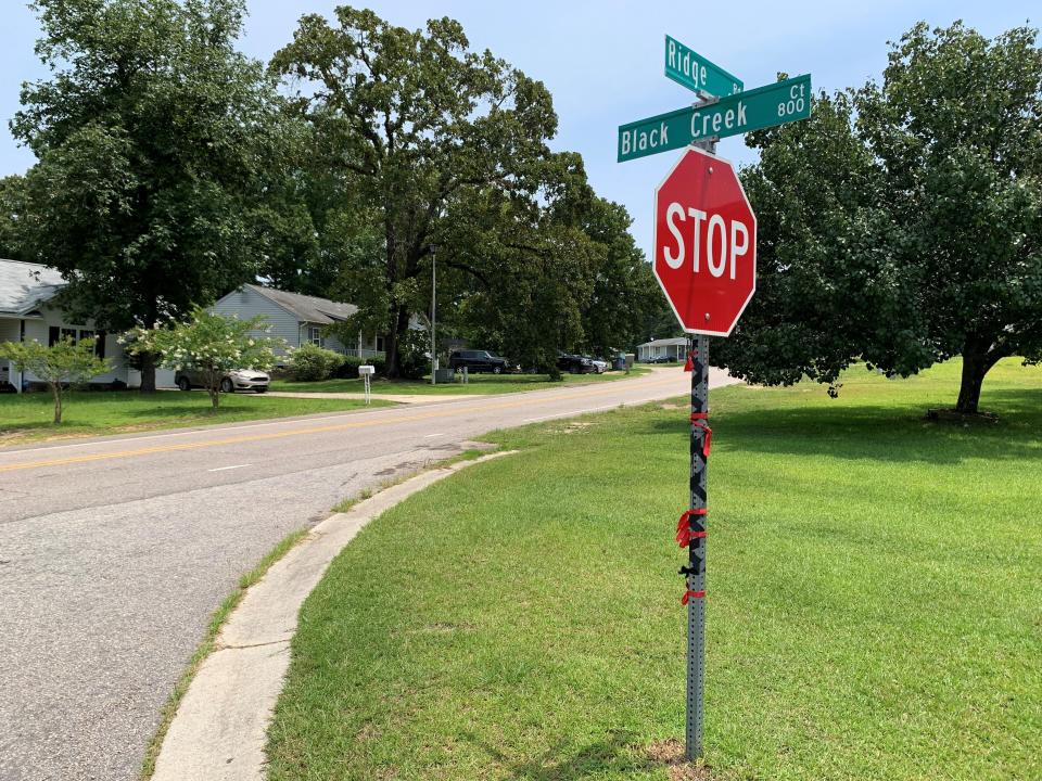 Black and red ribbons tied around the street sign at the corner of Ridge Road and Black Creek Court near where Ashanti Bellamy, 22, was shot and killed May 17.