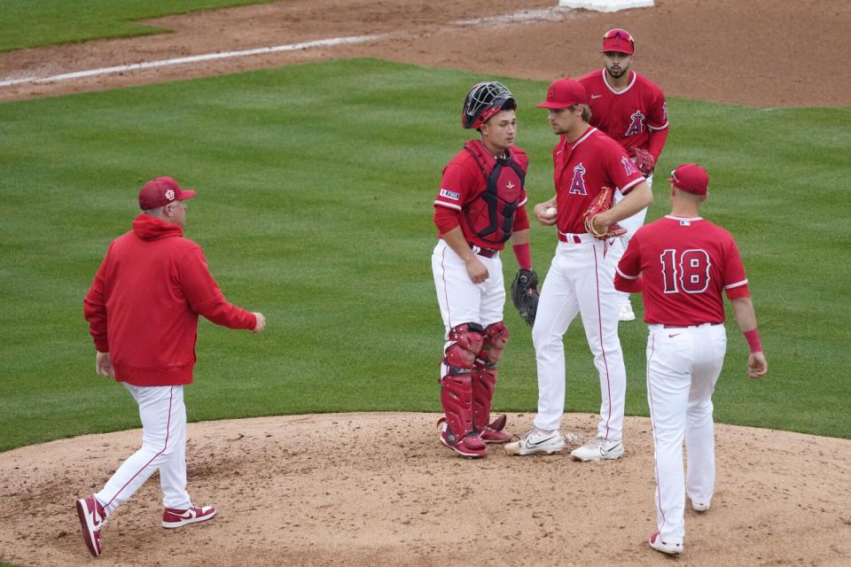 Angels pitcher Ben Joyce speaks to teammates as Angels manager Phil Nevin, left, arrives at the mound.