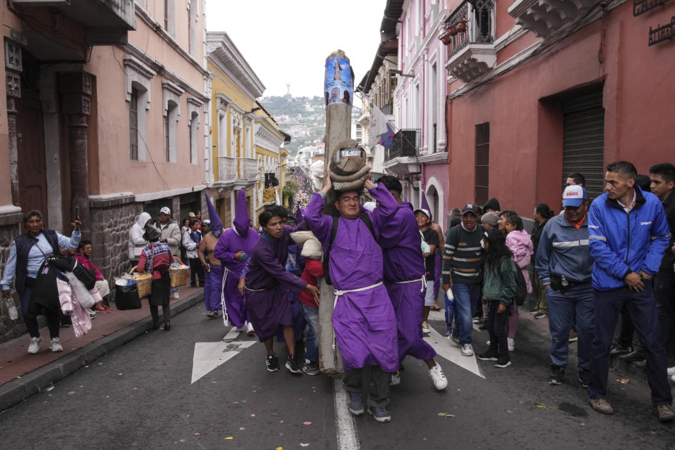 Penitents known as cucuruchos carry a large cross during the Jesus the Almighty Good Friday procession, as part of Holy Week celebrations, in Quito, Ecuador, Friday, March 29, 2024. Holy Week commemorates the last week of Jesus Christ’s earthly life which culminates with his crucifixion on Good Friday and his resurrection on Easter Sunday. (AP Photo/Dolores Ochoa)