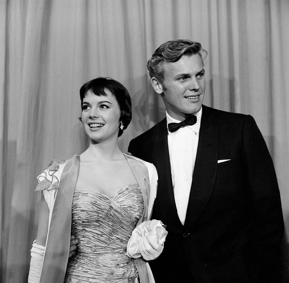 <p>In order to hide Hunter's closeted homosexuality, Hollywood studio publicity machines crafted faux relationships for the actor to take part in to derail the prying eye of the tabloids. Most famously, the square-jawed movie star was romantically linked to Natalie Wood, his co-star in<em> The Girl He Left Behind</em> and <em>The Burning Hills</em>, both of which were released in 1956.</p><p>Here, Natalie Wood and Tab Hunter pose on the red carpet as they attend the 28th Academy Awards in Los Angeles, CA. </p>