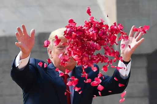 Donald Trump sprays rose petals to pay tribute at Raj Ghat, the memorial for Indian independence icon Mahatma Gandhi, in New Delhi