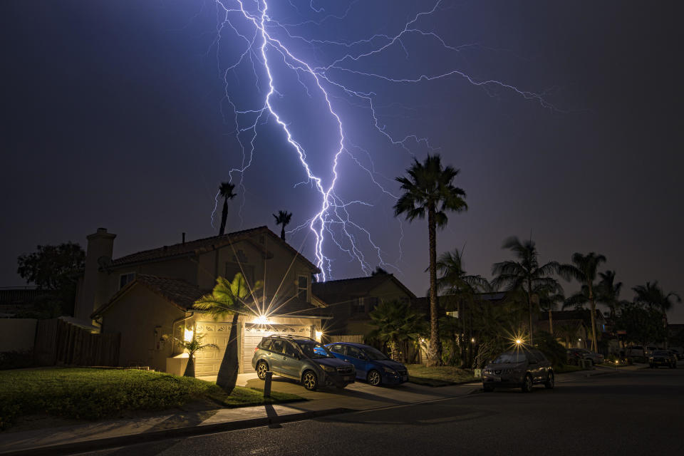 Lightning strikes over a home in Oceanside, California as a fast-moving storm passed through San Diego County on October 4, 2021 in Oceanside, California. / Credit: Daniel Knighton / Getty Images