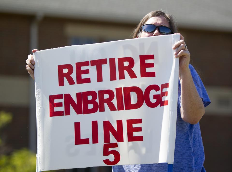 FILE - In this July 6, 2017, file photo, Lauren Sargent, takes part in a protest before the Enbridge Line 5 pipeline public information session in Holt, Mich. Environmentalists are challenging Michigan regulators' decision to approve encasing part of an aging Enbridge Energy oil pipeline that runs beneath a channel connecting two Great Lakes, arguing that they failed to properly consider alternatives that would minimize climate impacts. (Cory Morse/The Grand Rapids Press via AP, File)