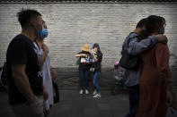 People wearing face masks to protect against the spread of the new coronavirus walk along a pedestrian shopping street in Beijing, Saturday, May 16, 2020. According to official data released on Saturday India's confirmed coronavirus cases have surpassed China's. (AP Photo/Mark Schiefelbein)