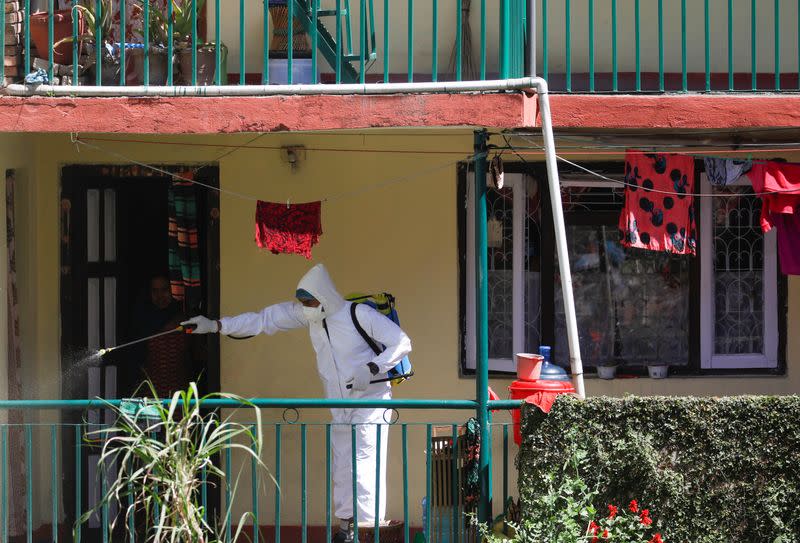 A volunteer sprays disinfectant outside a house during the tenth day of the lockdown imposed by the government amid concerns about the spread of coronavirus disease (COVID-19) outbreak, in Kathmandu