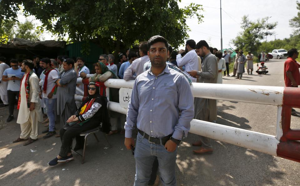 Supporters of Pakistan's former Prime Minister Imran Khan's party gather outside his residence in Islamabad, Pakistan, Monday, Aug. 22, 2022. Pakistani police have filed terrorism charges against Khan, authorities said Monday, escalating political tensions in the country as the ousted premier holds mass rallies seeking to return to office. (AP Photo/Anjum Naveed)