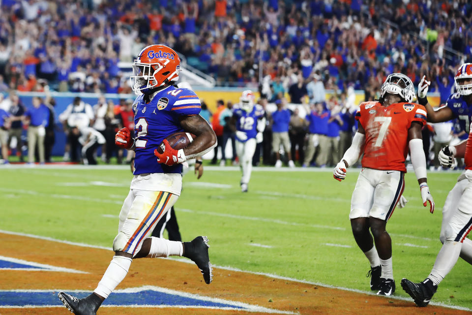 Virginia safety Chris Moore (7) reacts as Florida running back Lamical Perine (2) scores during the first half of the Orange Bowl NCAA college football game, Monday, Dec. 30, 2019, in Miami Gardens, Fla. (AP Photo/Brynn Anderson)