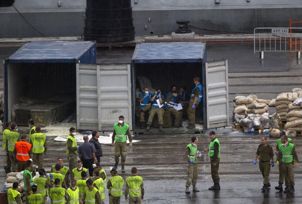 Israeli soldiers work around containers with boxes containing missiles and weapons unloaded from the seized KLOS C civilian cargo ship, in the military port at the Red Sea city of Eilat, southern Israel, Sunday, March 9, 2014. Israel's prime minister is calling on the European Union's foreign policy chief, currently visiting Tehran, to confront Iranian officials about the weapons Israel says it caught last week en route from Iran to militants in Gaza. Israel is preparing a public display of the cargo, said to include advanced rockets, hoping to pressure world powers as they negotiate with Tehran. (AP Photo/Ariel Schalit)