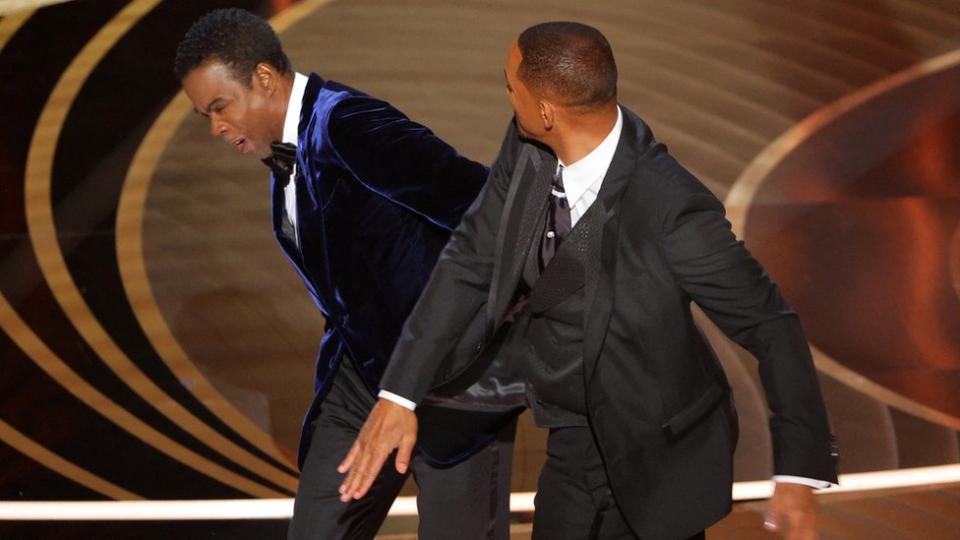 Will Smith (R) hits Chris Rock as Rock spoke on stage during the 94th Academy Awards in Hollywood, Los Angeles, California, U.S., March 27, 2022. REUTERS/Brian Snyder