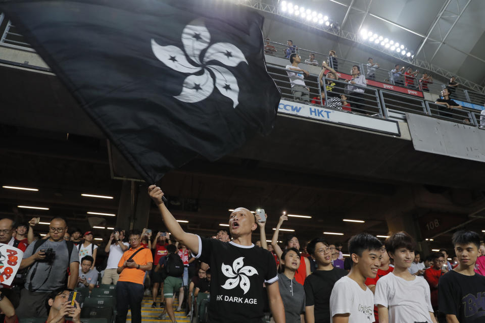 Hong Kong soccer fans waves a black version of the Hong Kong flag to protest against government during the FIFA World Cup Qatar 2022 and AFC Asian Cup 2023 Preliminary Joint Qualification Round 2 soccer match between Hong Kong and Iran, in Hong Kong, Tuesday, Sept. 10, 2019. The crowd broke out into "Glory to Hong Kong," a song reflecting their campaign for more democratic freedoms in the semi-autonomous Chinese territory. (AP Photo/Kin Cheung)