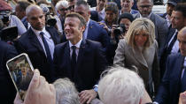 French President Emmanuel Macron and his wife Brigitte Macron greet the crowd as they arrive at Jackson Square in New Orleans, Friday, Dec. 2, 2022. (AP Photo/Gerald Herbert)