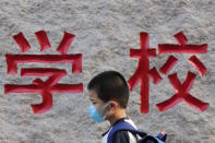 A student wearing a face mask to help curb the spread of the coronavirus arrives to a primary school in Beijing, Monday, Sept. 7, 2020. Students in the capital city returned to school on Monday in a staggered start to the new school year because of the coronavirus outbreak. (AP Photo/Andy Wong)