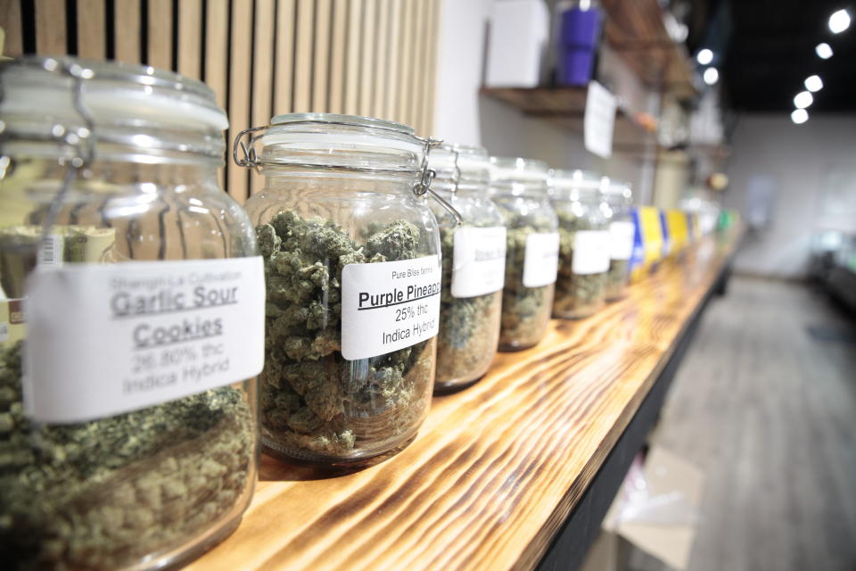 Jars of marijuana line a shelf at The Flower Shop Dispensary in Sioux Falls, S.D. on Oct. 14, 2022. South Dakota's legal pot industry has started with medical cannabis, but voters are deciding whether to also legalize recreational pot. (AP Photo/Stephen Groves)