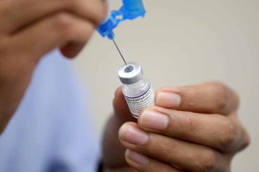 DELANO, CA - NOVEMBER 17: Rodolfo Gonzalez, of Fresno, a pharmacist intern with Kumoto Pharmacy, prepares Pfizer-BioNTech COVID-19 vaccinations administered by the Delano Union School District Student Support Services in partnership with the California Farmworkers Foundation in the Central Valley on Wednesday, Nov. 17, 2021 in Delano, CA. (Gary Coronado / Los Angeles Times)