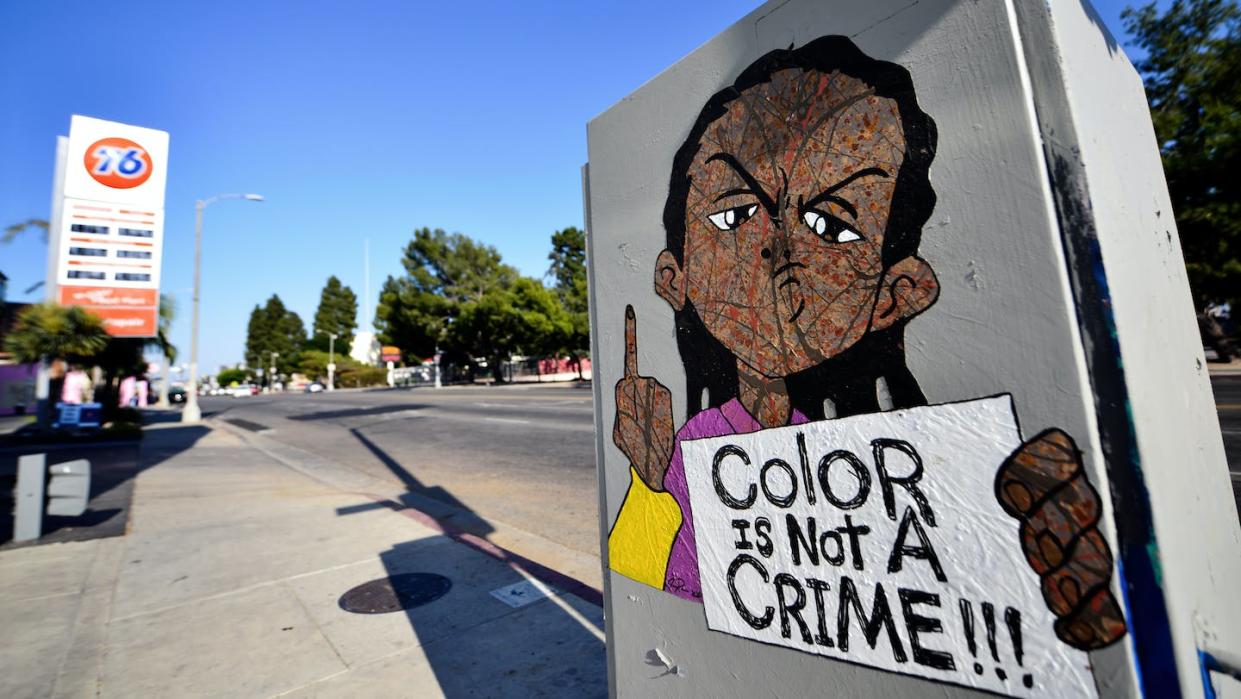 A character from 'The Boondocks' is depicted in street art in Los Angeles during the time of the Black Lives Matter protests of 2020. <a href="https://www.gettyimages.com/detail/news-photo/street-art-reading-color-is-not-a-crime-is-left-on-the-news-photo/1251233651?phrase=aaron%20mcgruder&adppopup=true" rel="nofollow noopener" target="_blank" data-ylk="slk:Chelsea Guglielmino via Getty Images;elm:context_link;itc:0;sec:content-canvas" class="link ">Chelsea Guglielmino via Getty Images</a>