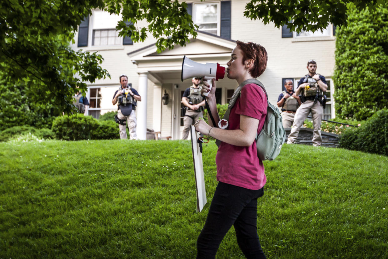 Federal marshals stand guard as a pro-choice protester marches past at Supreme Court Chief Justice John Roberts' house in Chevy Chase, Md., on May 18, 2022. (Allison Bailey / NurPhoto via AP)