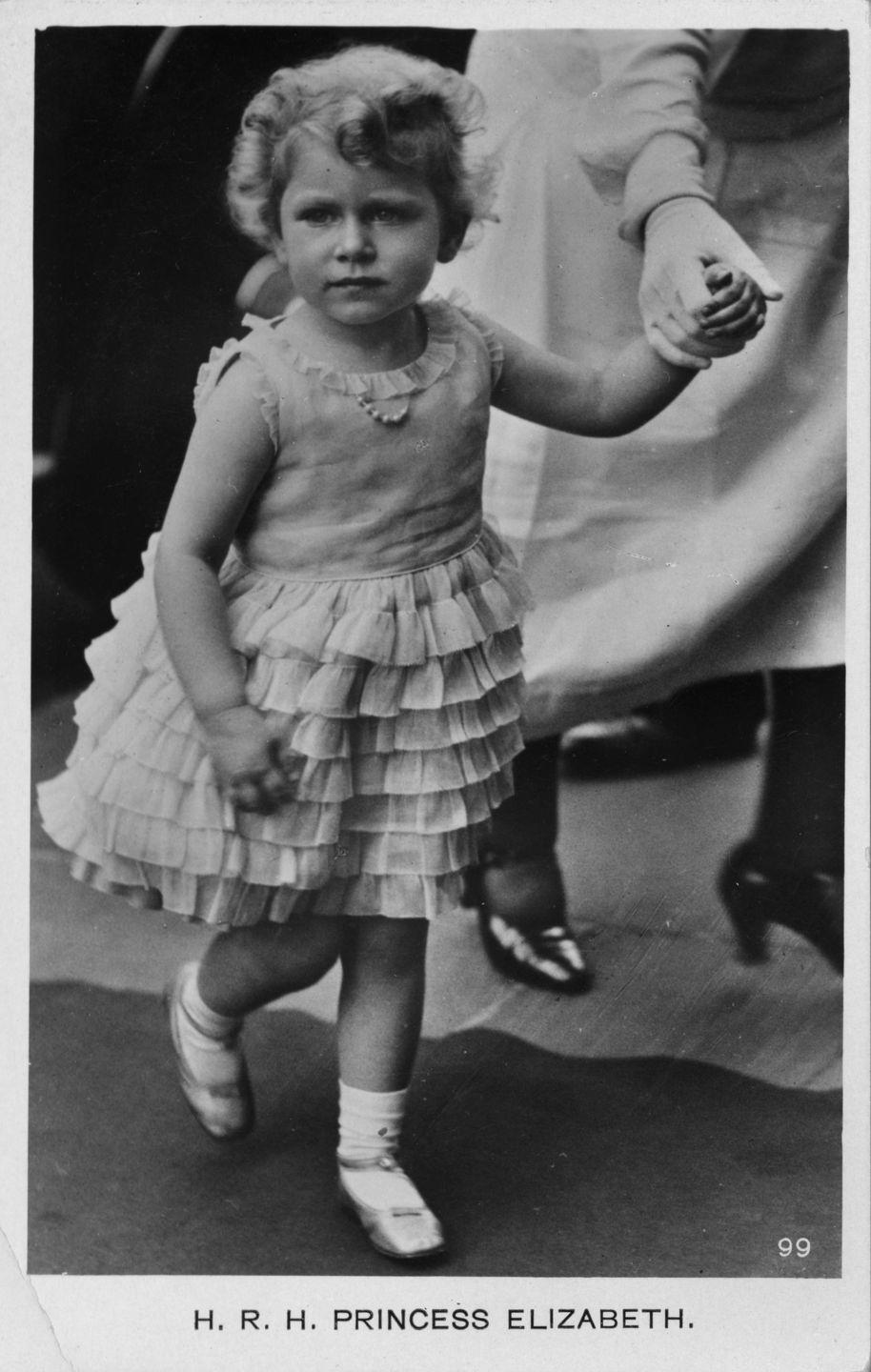 <p>Looking strikingly similar to her great-granddaughter, Princess Charlotte, a young Queen Elizabeth shows off a ruffled tulle party dress—and a pearl necklace, of course. </p>