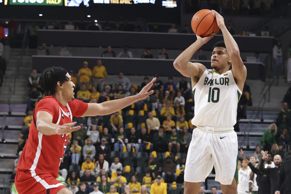 Baylor guard RayJ Dennis (10) attempts a three point shot over Texas Tech guard Darrion Williams (5) during the first half of an NCAA college basketball game Tuesday, Feb. 6, 2024, in Waco, Texas. (AP Photo/Jerry Larson)