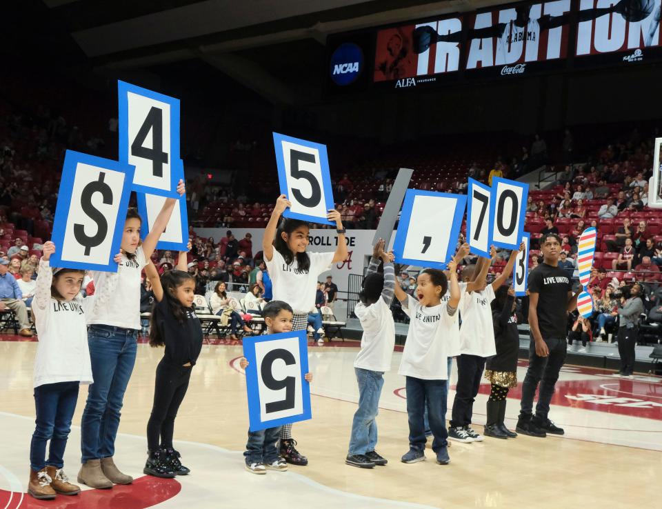 Dec 23, 2023; Tuscaloosa, Alabama, USA; Children lift numbers as the United Way of West Alabama announces their fundraising goal total during halftime of the Alabama game against Eastern Kentucky at Coleman Coliseum. Mandatory Credit: Gary Cosby Jr.-USA TODAY Sports