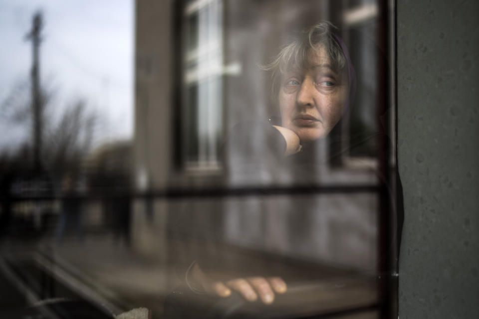 A woman who fled a nearby village looks out from a window of a church in Bashtanka, Mykolaiv district, Ukraine, on Thursday, March 31, 2022. (AP Photo/Petros Giannakouris)