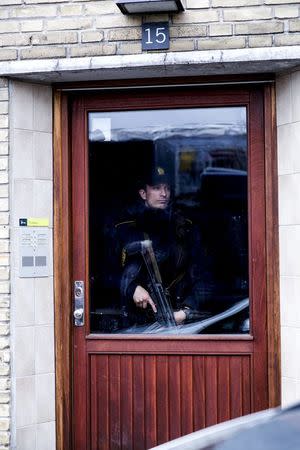 Policeman stands guard in an apartment block during a search for suspects believed to have travelled to Syria to join the Islamic State, in Tingbjerg, Copenhagen, April 7, 2016. REUTERS/Uffe Weng/Scanpix Denmark