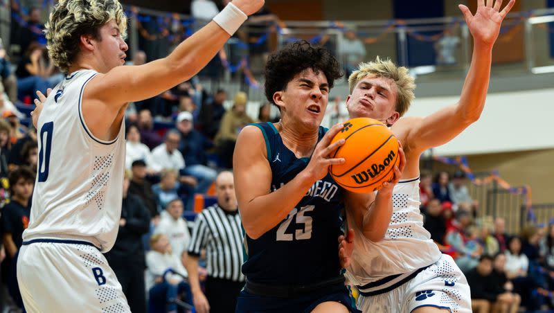 Juan Diego’s Tevarii Pecqueux drives the ball with Brighton’s Nash Matheson, left, and Kaden Morzelewski, right, on defense in the second round playoff game for 5A high school boys basketball at Brighton High School in Cottonwood Heights on Wednesday, Feb. 21, 2024.