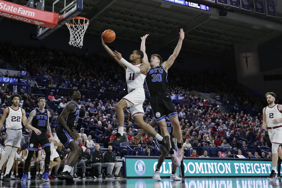 Gonzaga guard Nolan Hickman (11) shoots while defended by BYU guard Dallin Hall (30) during the second half of an NCAA college basketball game Saturday, Feb. 11, 2023, in Spokane, Wash. Gonzaga won 88-81. (AP Photo/Young Kwak)