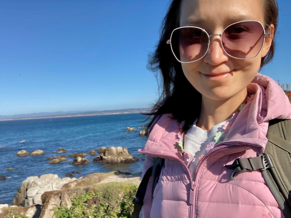 anna posing for a selfie in front of a body of water