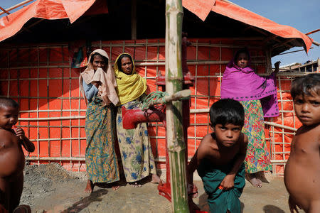 Rohingya refugees gather around a water pump in the camp for widows and orphans inside the Balukhali camp near Cox's Bazar, Bangladesh, December 5, 2017. More than 230 women and children live at a so-called widows camp built by fellow refugees with the help of donor funds for Rohingya widows and orphans to offer them better protection and shelter. REUTERS/Damir Sagolj