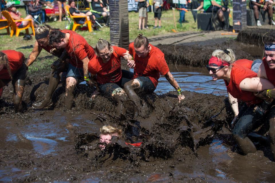 The Orangetheory Fitness team wallows through the Mudderhorn obstacle on the last stretch of the Tough Mudder Chicago 5K at Chicago-Rockford International Airport Saturday, Aug. 14, 2021, in Rockford. The Tough Mudder Chicago returns to Rockford this weekend.