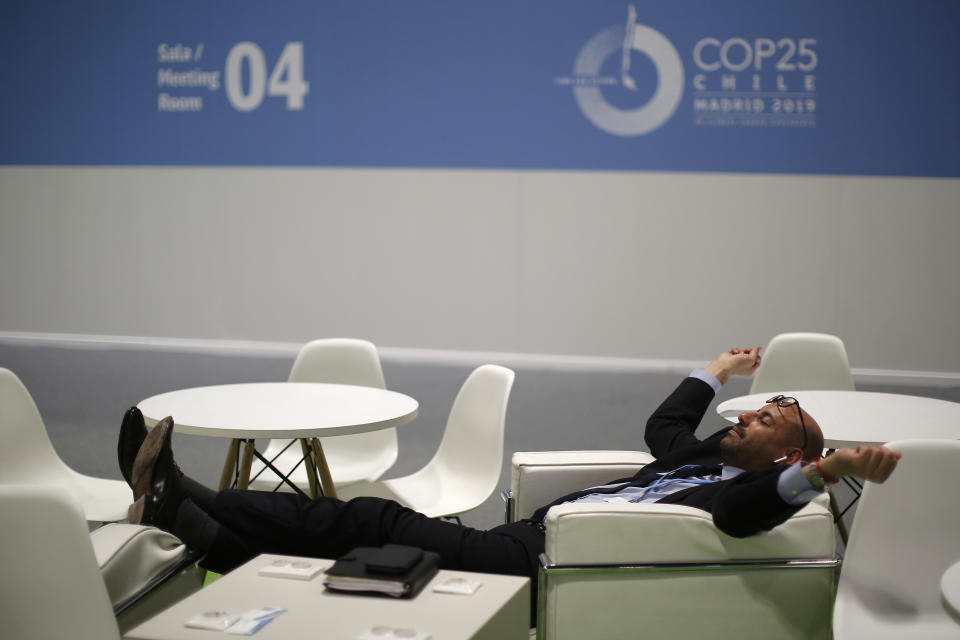 A visitor rests at the COP25 climate talks congress in Madrid, Spain, Saturday, Dec. 14, 2019. The United Nations Secretary-General has warned that failure to tackle global warming could result in economic disaster. (AP Photo/Manu Fernandez)