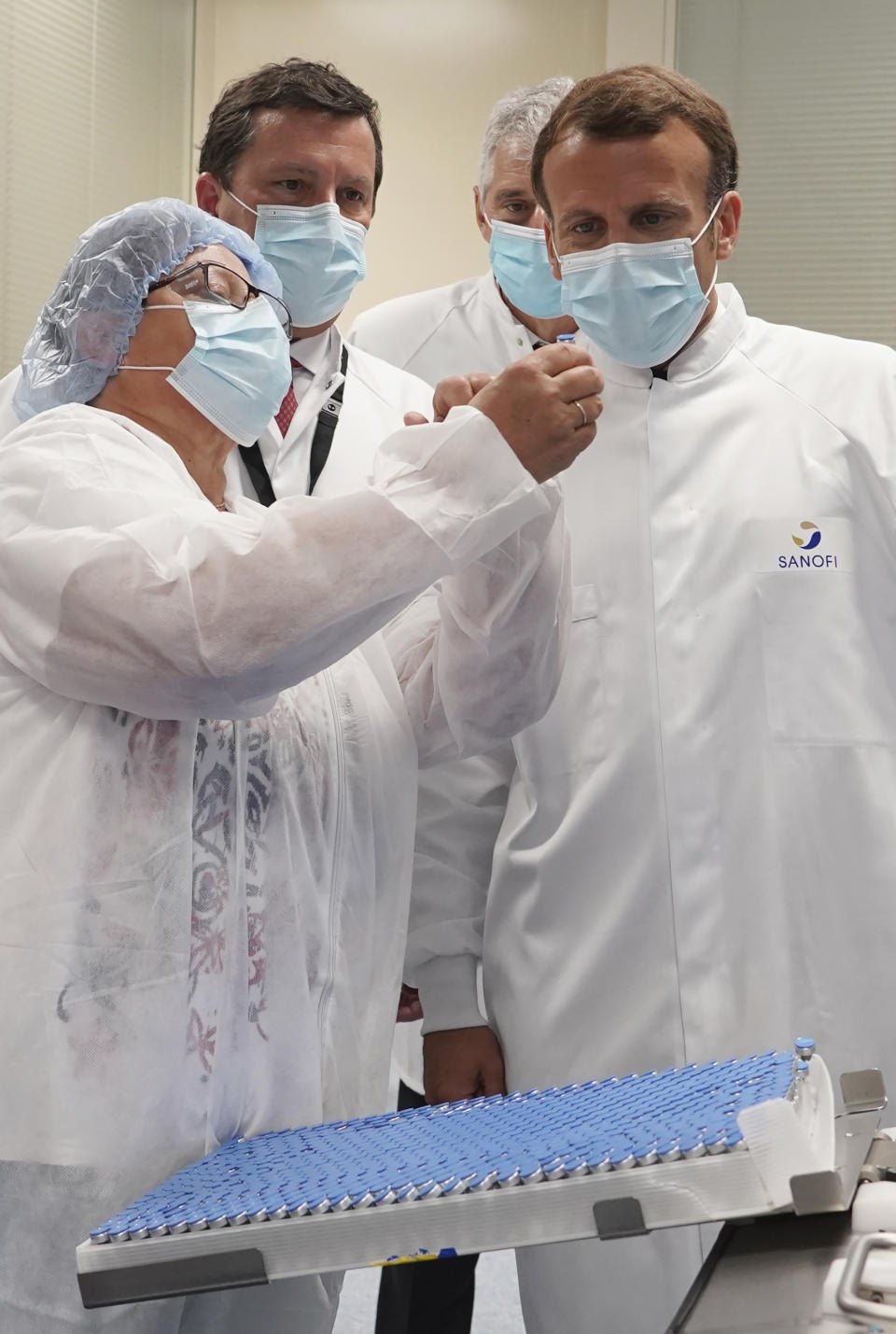 French President Emmanuel Macron listens to a researcher as he visits an industrial development laboratory at French drugmaker's vaccine unit Sanofi Pasteur plant in Marcy-l'Etoile, near Lyon, central France, Tuesday, June 16, 2020.The visit comes after rival pharmaceutical company AstraZeneca this weekend announced a deal to supply 400 million vaccine doses to EU countries, including France. (AP Photo/Laurent Cipriani, Pool)