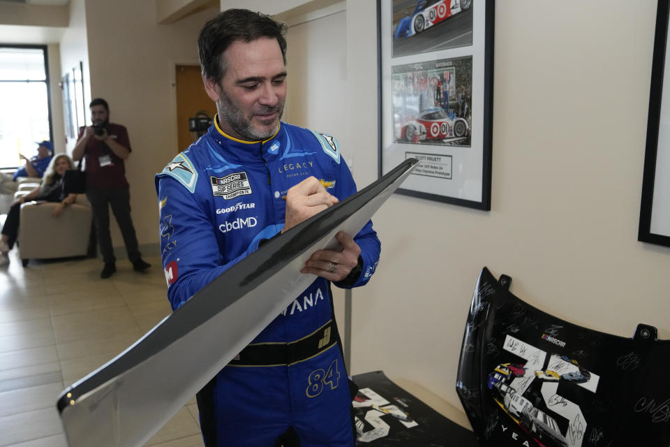 Jimmie Johnson autographs NASCAR memorabilia during Daytona 500 auto race media day at Daytona International Speedway, Wednesday, Feb. 15, 2023, in Daytona Beach, Fla. (AP Photo/John Raoux)