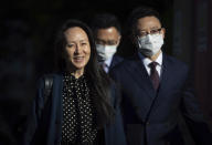 Meng Wanzhou, left, chief financial officer of Huawei, leaves her home in Vancouver, on Friday, Sept. 24, 2021. U.S. prosecutors are prepared to resolve criminal charges against the chief financial officer of Chinese communications giant Huawei Technologies, the Justice Department disclosed Friday in a letter to a federal judge in New York.(Darryl Dyck/The Canadian Press via AP)