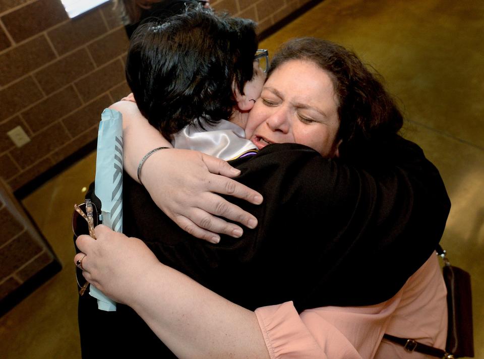 English Associate Professor and Department Chair for the English and Humanities Department Spring Hyde gives a tearful hug to her former student Miguel Reyes of Puerto Rico following the commencement at Lincoln College Saturday May 7, 2022. Hyde has worked at the college for 16 years and this will be the last commencement because the college is closing. [Thomas J. Turney/The State Journal-Register]