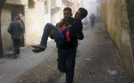 Members of the Syrian Civil Defense group, known as the White Helmets, carry a young man who was wounded during air strikes and shelling by Syrian government forces in Eastern Ghouta (AP)