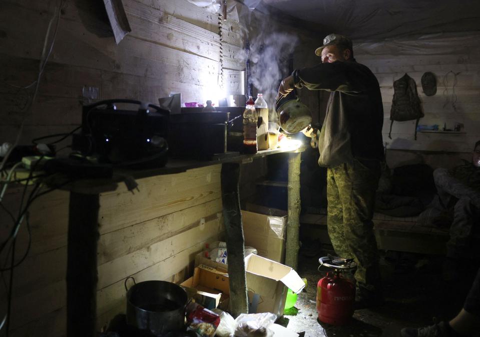 A Ukrainian serviceman of the 10th Mountain Assault Brigade “Edelweiss” seen heating water in a dugout at a front line position near Bakhmut in the Donetsk region yesterday (AFP via Getty Images)