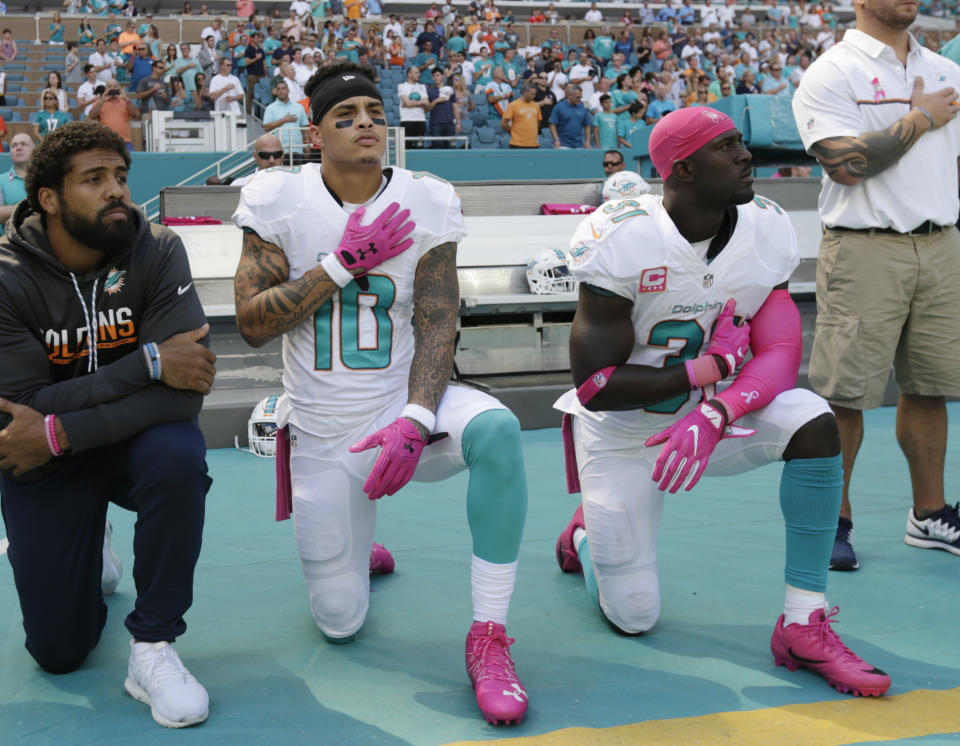 Miami Dolphins wide receiver Kenny Stills (10) and free safety Michael Thomas (31) kneel during the national anthem before a 2016 game. (AP)